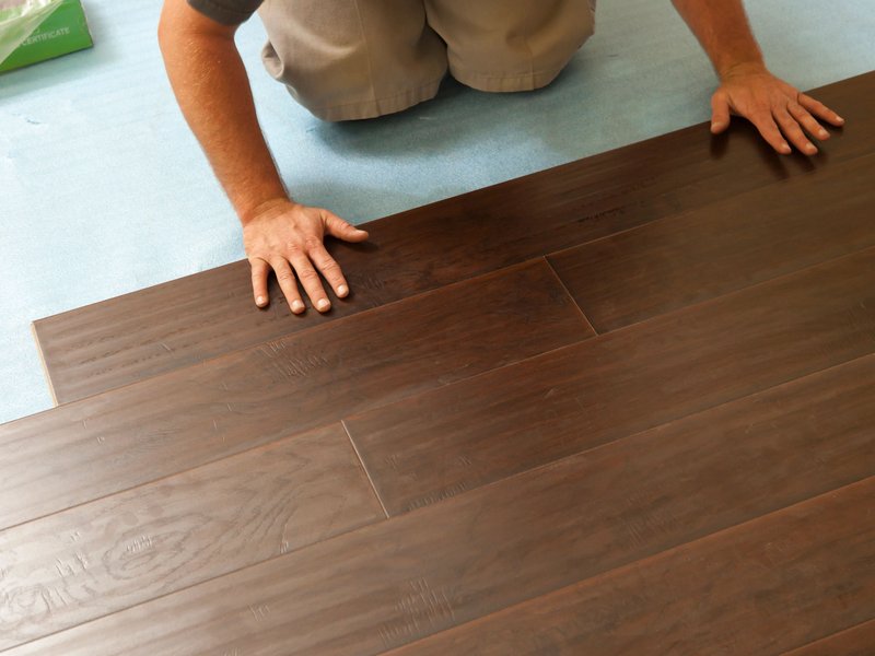 Person installing engineered hardwood flooring from Capitol Carpet in Dalton, GA